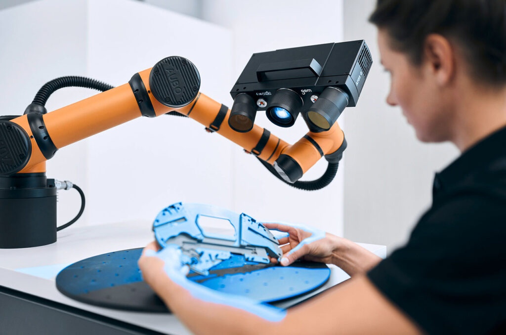 Precision 3D scanning by Zeiss with an industrial robotic arm measuring a blue component